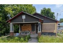 Exterior of home showing gray siding, stone porch, and overgrown front yard at 854 Mcdonough Se Blvd, Atlanta, GA 30315