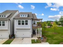 Charming two-story home featuring a one-car garage, a cozy balcony, and a well-manicured lawn at 319 Hayden Cir, Woodstock, GA 30189