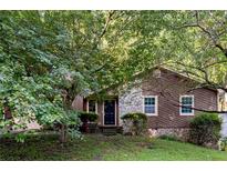 Charming home featuring stone accents, newer windows, and mature trees at 4039 Tanglewood Rd, Snellville, GA 30039