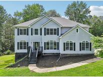 Charming two-story home with gray siding, black shutters, and a well-manicured front yard at 4685 Braselton Hwy, Hoschton, GA 30548