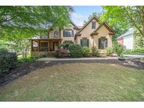 Charming two-story home featuring a well-manicured lawn and beautiful landscaping with mature trees at 3438 Winborn Walk Northwest Nw, Kennesaw, GA 30152