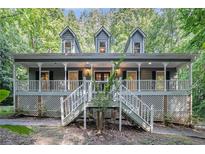 Charming home with a large front porch, detailed railings and three dormer windows above at 1488 White Columns Blvd, Canton, GA 30115