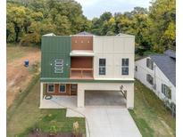 Modern exterior featuring a two-car carport, balcony, and stylish green and neutral-toned siding at 2312 Herring Sw Rd, Atlanta, GA 30311