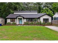 Charming single-story home with manicured lawn, flowerbeds, and a bright blue front door at 1218 Crestwood Se Dr, Atlanta, GA 30316