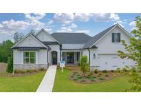 Beautiful single-Gathering home featuring a two-car garage, manicured lawn, and stone accents under sunlit skies at 309 Brooke View Trail, Canton, GA 30115
