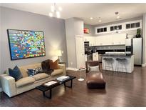Open-concept living room with modern decor, hardwood floors, and a view into the kitchen at 560 Dutch Valley Road # 2412, Atlanta, GA 30324