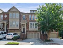 Beautiful townhome with a brick facade, arched entryway, and attached two-car garage at 2873 Overlook Ne Way, Atlanta, GA 30324