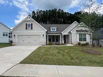 Charming single-story home featuring a two-car garage and well-manicured lawn at 608 Southland Pass, Canton, GA 30115