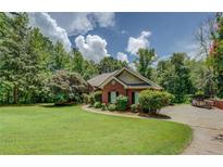 Charming brick home with a well-manicured lawn and mature trees offers great curb appeal at 1041 Flat Rock Rd, Covington, GA 30014