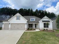 Beautifully designed white home featuring a three-car garage and a well-manicured lawn at 314 Brooke View Trail, Canton, GA 30115