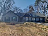 Charming single-story home with a well-maintained front yard, featuring mature trees and a lovely, classic facade at 4465 Kent Rd, Atlanta, GA 30337
