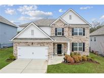 Charming two-story home with a well-manicured lawn, brick facade, and an attached two-car garage at 4365 Sunflower Cir, Cumming, GA 30040