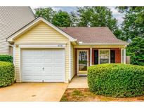 Charming home featuring a one-car garage, well-maintained landscaping, and inviting front entrance at 455 Lakeside Cir, Covington, GA 30016