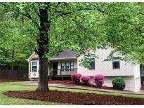 Charming single-Gathering home with a cozy front porch and lush landscaping at 647 Sunshine Nw Trce, Acworth, GA 30102