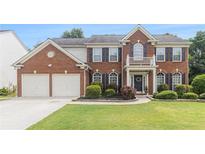 Beautiful two-story brick home with manicured lawn, shutters and white trim accents at 122 Susobell Pl, Woodstock, GA 30188