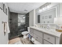 Modern bathroom featuring a glass-enclosed shower, gray vanity with granite countertop, and wood-look flooring at 3115 Seven Pines Ct # 308, Atlanta, GA 30339