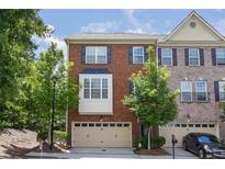 Charming brick townhome featuring a two-car garage and inviting curb appeal at 5060 Windcrest Lane, Alpharetta, GA 30022