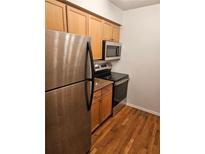 Well-lit kitchen featuring stainless steel appliances, wood cabinets, and granite countertops at 1150 Collier Nw Rd # 12F, Atlanta, GA 30318