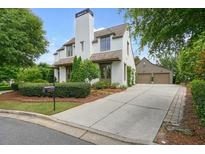 Charming home with a manicured front yard, long driveway, and detached garage providing ample parking at 6930 Wesley Hughes Rd, Cumming, GA 30040