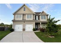Charming two-story home with a well-manicured lawn, two-car garage, and a welcoming front entrance at 7703 Hansel Ln, Lithonia, GA 30058