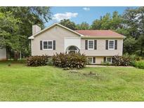Charming split-level home featuring a well-manicured lawn, traditional siding, and decorative shutters at 73 Azalea Dr, Villa Rica, GA 30180