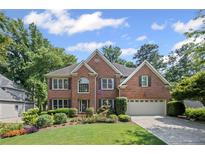 Charming brick home with a manicured lawn, colorful flowerbeds, and an attached two-car garage at 3675 Ridgeway Ter, Suwanee, GA 30024