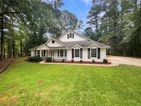 Charming one-story home with white siding, black shutters, and a well-maintained green lawn at 46 Timber Walk Dr, Sharpsburg, GA 30277