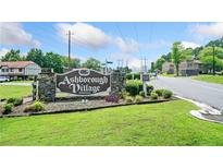 Ashborough Village Condominiums sign with stone base and manicured lawn welcomes residents and guests at 1810 Ashborough Se Rd # G, Marietta, GA 30067