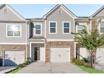 Charming townhouse exterior with stone accents, gray siding, and attached garage at 1958 Dillon Dr, Lithonia, GA 30058