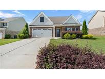 Charming brick home featuring an attached two-car garage, landscaped yard, and manicured lawn at 196 Al Jennah Blvd, Locust Grove, GA 30248