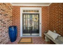 Inviting front entrance with a double door, brick surround, and decorative wreath for a warm, welcoming feel at 3502 Village Green Dr, Roswell, GA 30075
