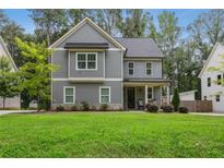 Charming two-story home with gray siding, a manicured lawn, and a welcoming front porch at 2362 Browns Mill Rd, Atlanta, GA 30315