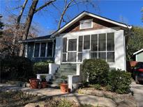 Charming home featuring a screened porch and landscaped front yard with mature trees at 284 Lakeview Ne Ave, Atlanta, GA 30305