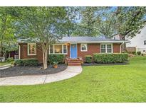 Charming brick home with a well-maintained lawn, manicured hedges, and a bright blue front door at 2057 Cambridge Ave, Atlanta, GA 30337