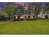 Charming brick home featuring a well-manicured lawn and inviting blue front door at 2057 Cambridge Ave, Atlanta, GA 30337