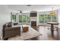 Bright living room with fireplace, large windows, ceiling fan and wood floors at 244 13Th Ne St # 302, Atlanta, GA 30309