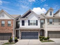 Charming two-story home with a two car garage, white siding, and well-maintained landscaping at 5715 Radford Loop # 15, Fairburn, GA 30213