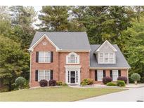 Charming two-story brick home with manicured lawn and traditional architectural details at 3500 Parkwood Hills Ct, Snellville, GA 30078