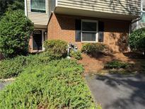 Traditional brick townhome featuring a covered entrance surrounded by lush green shrubbery at 40 Dunwoody Springs Dr, Atlanta, GA 30328