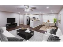 Bright living room open to kitchen with stainless appliances, and hardwood floors at 6494 Bimini Dr, Forest Park, GA 30297