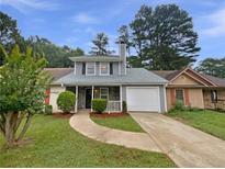 Charming home with a well-maintained front yard and a driveway leading to an attached garage at 8332 Mountain Pass, Riverdale, GA 30274