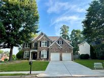 Charming two-story brick home with a well-manicured lawn and attached two-car garage at 1055 Havenstone Walk, Lawrenceville, GA 30045