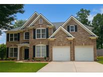 Charming two-story brick home with a well-manicured lawn, a two-car garage, and traditional black shutters at 1055 Havenstone Walk, Lawrenceville, GA 30045