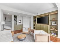 Comfortable living room with green built-ins, hardwood floors, and a modern seating arrangement at 145 15Th Ne St # 1209, Atlanta, GA 30309
