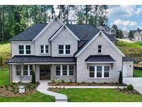 Beautiful two-story home with a light brick exterior, lush lawn, and dark metal awning accents at 2455 Bleckley Pl, Cumming, GA 30041