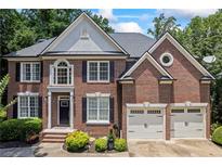 Charming brick home featuring a well-manicured lawn and a two-car garage at 1547 Grove Arbor Ter, Dacula, GA 30519