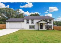 Charming two-story home with a lush green lawn and a spacious two-car garage at 932 Brian Ln, Forest Park, GA 30297