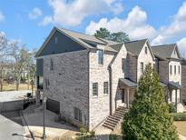 Beautiful brick townhome featuring a two-car garage, a gabled roof, and a manicured lawn at 2850 Stonehall Se Ct, Smyrna, GA 30080