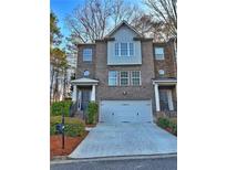 Charming brick townhome with a two-car garage and manicured landscaping at 602 Birch River Ln, Lawrenceville, GA 30043