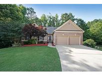 Charming single-story home boasts a manicured lawn, two-car garage, and inviting entrance with lush landscaping at 450 Hunt Creek Dr, Acworth, GA 30101